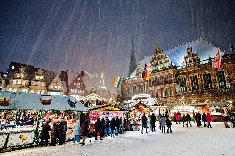 Das Bremer Rathaus bildet den historischen Rahmen für den Weihnachtsmarkt. Archivaufnahme bei Schneefall. Foto: Tristan Vankann.