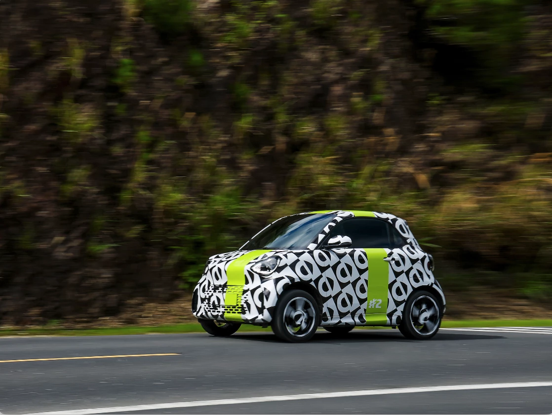  Der smart #2 durchläuft derzeit ein strenges weltweites Testprogramm im Vorfeld der Weltpremiere auf dem Pariser Autosalon im Oktober dieses Jahres. Da die Neuauflage des Zweisitzers weltweit an Dynamik gewinnt, ist der smart #2 nun in einer maßgeschneiderten schwarz-weißen Tarnlackierung auf den Straßen unterwegs. © smart Europe GmbH