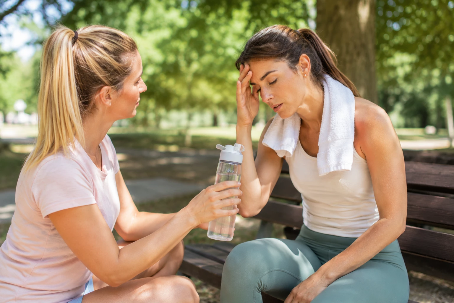 Schwindel, Müdigkeit oder Kopfschmerzen können erste Anzeichen dafür sein, dass dein Körper mehr Flüssigkeit benötigt. Eine Pause im Schatten und ausreichend Wasser sind jetzt besonders wichtig. (KI-generiert)