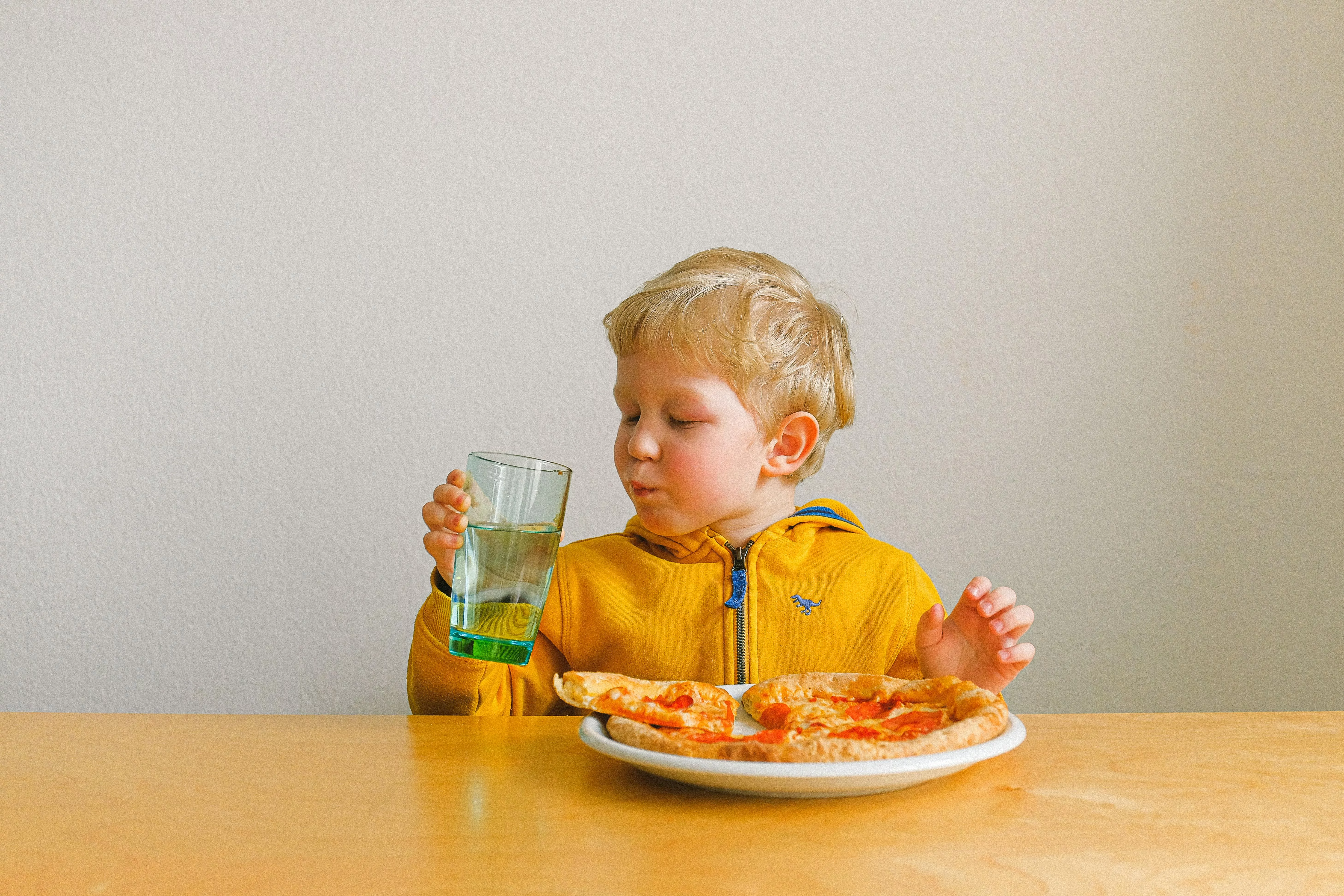 kleiner Junge beim Pizzaessen